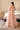 Coral Bliss coral peach bridal lehenga choli with the net dupatta spread out, full length