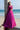 Lyric magenta bridesmaid lehenga choli in a side pose with the sheer net dupatta draped over the shoulder