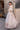 Full-length Mystic Rose white bridal lehenga choli in a sunlit courtyard, Pakistani couture