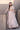 Mystic Rose white lehenga choli from the side, styled with an embellished potli
