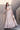 Mystic Rose white nikkah lehenga choli photographed on the steps with the embellished net dupatta