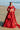Ruby red Pakistani bridal lehenga choli, full front view on the beach with embroidered net lehenga and embellished dupatta