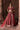 Bazaar light burgundy velvet Pakistani lehenga choli by Waqas Shah, front view with organza dupatta between brick pillars