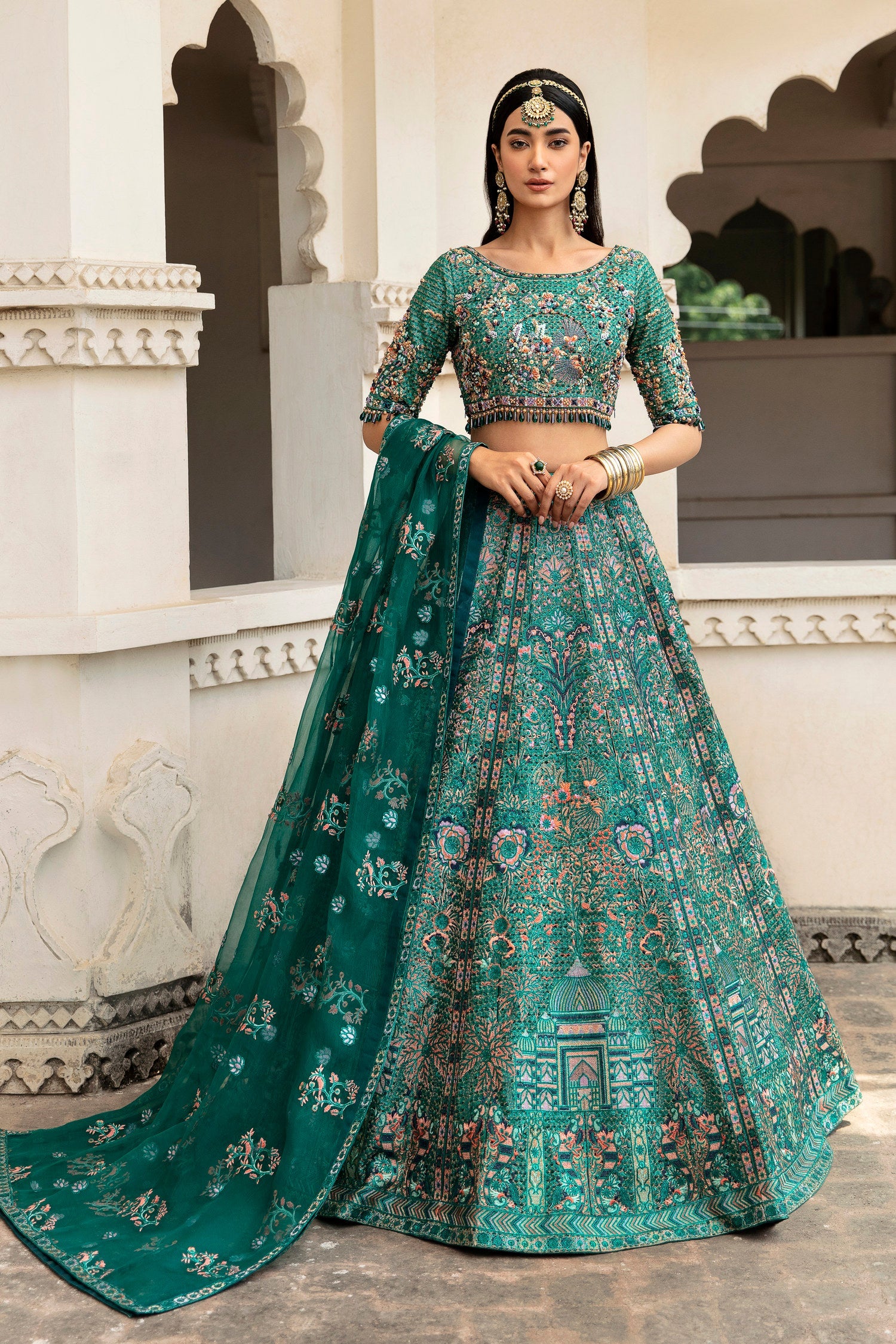 Mehar Bano bottle green Mughal lehenga choli by Waqas Shah, full front view under carved Mughal arches