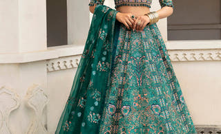 Mehar Bano bottle green Mughal lehenga choli by Waqas Shah, full front view under carved Mughal arches