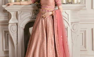 Primrose tea pink sequin lehenga choli by Waqas Shah, full front view beside a marble fireplace