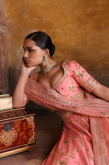 Avnoor salmon pink Pakistani lehenga choli reclining portrait with kundan choker and organza dupatta