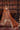 Gurleen rust brown lehenga with sitara organza dupatta spread wide against a carved wooden door