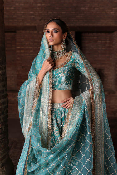 Manzil teal velvet lehenga choli handcrafted in Lahore, with floral bel jaal and copper kiran dupatta