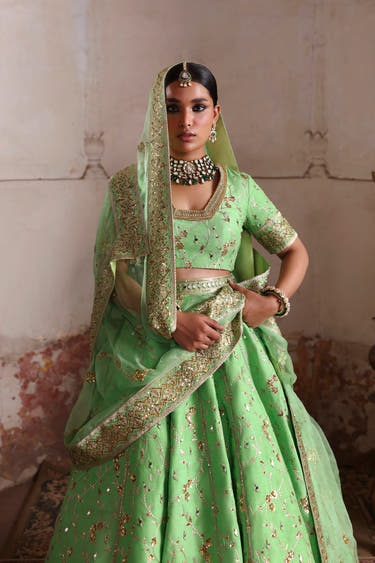 Zeba pistachio green Pakistani bridal lehenga with embroidered organza dupatta draped over the head for nikkah