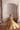 Saanvi skin gold bridal lehenga choli, seated under a carved white arch