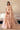 Coral Bliss coral peach bridal lehenga with the embellished dupatta trailing behind