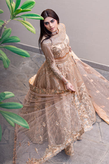 Golden Patel golden lehenga choli seen from the side with the net dupatta flowing, Pakistani bridal couture