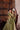 Back view of the Mahira olive green choli with the hand-embellished back hem and tassel latkan, reflected in an antique mirror