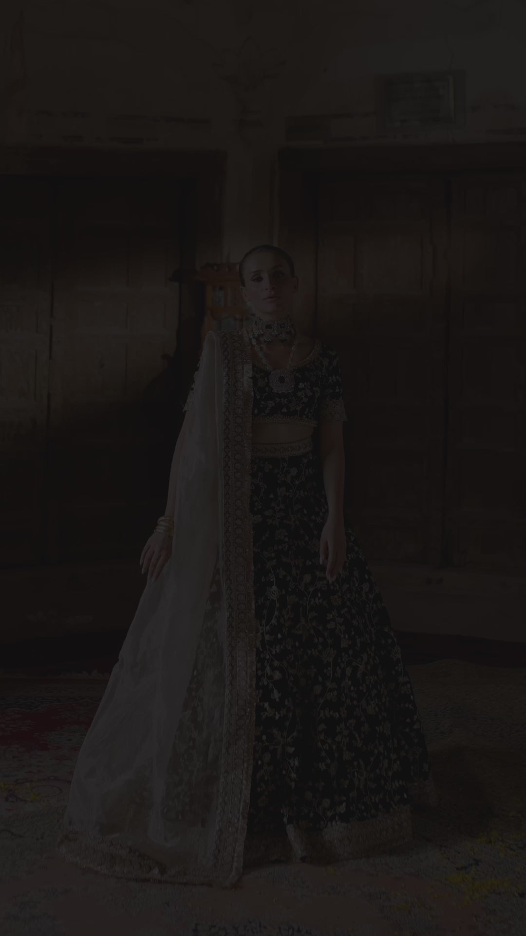 Video of the Taseer dark green velvet lehenga choli in motion, showing the gold zari jaal, hem border and ivory tissue dupatta