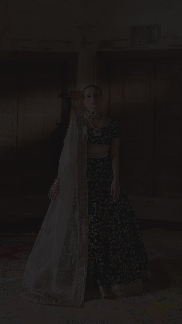 Video of the Taseer dark green velvet lehenga choli in motion, showing the gold zari jaal, hem border and ivory tissue dupatta