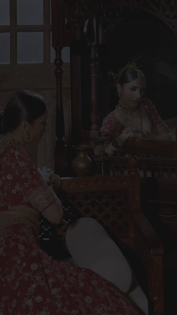 Bazaar light burgundy velvet Pakistani lehenga choli in motion, showing the floral vine embroidery, open back with tassel ties and fringed organza dupatta