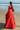 Back view of the Ruby red bridal lehenga choli on the beach with the flared embroidered skirt