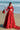 Ruby red bridal lehenga choli styled with a hand-embellished potli
