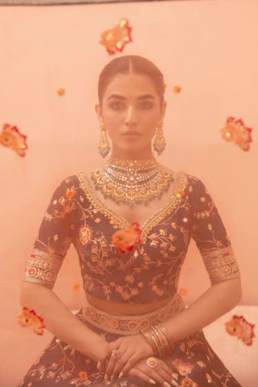 Shah Bano dark green lehenga choli seen through the peach organza dupatta